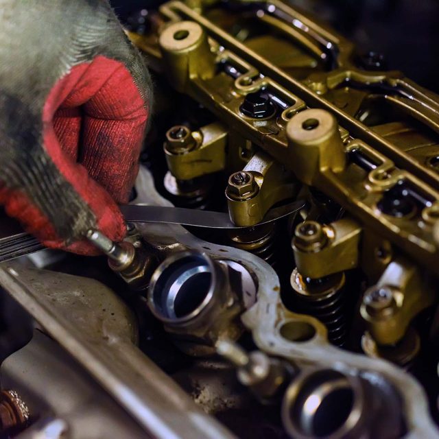 Auto mechanic repair engine in a car repair shop. Close up of cylinder head show rocker arm for maintenance check and adjust valve clearance