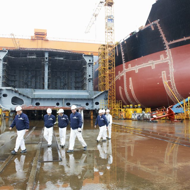 Workers walking across shipyard, GoSeong-gun, South Korea