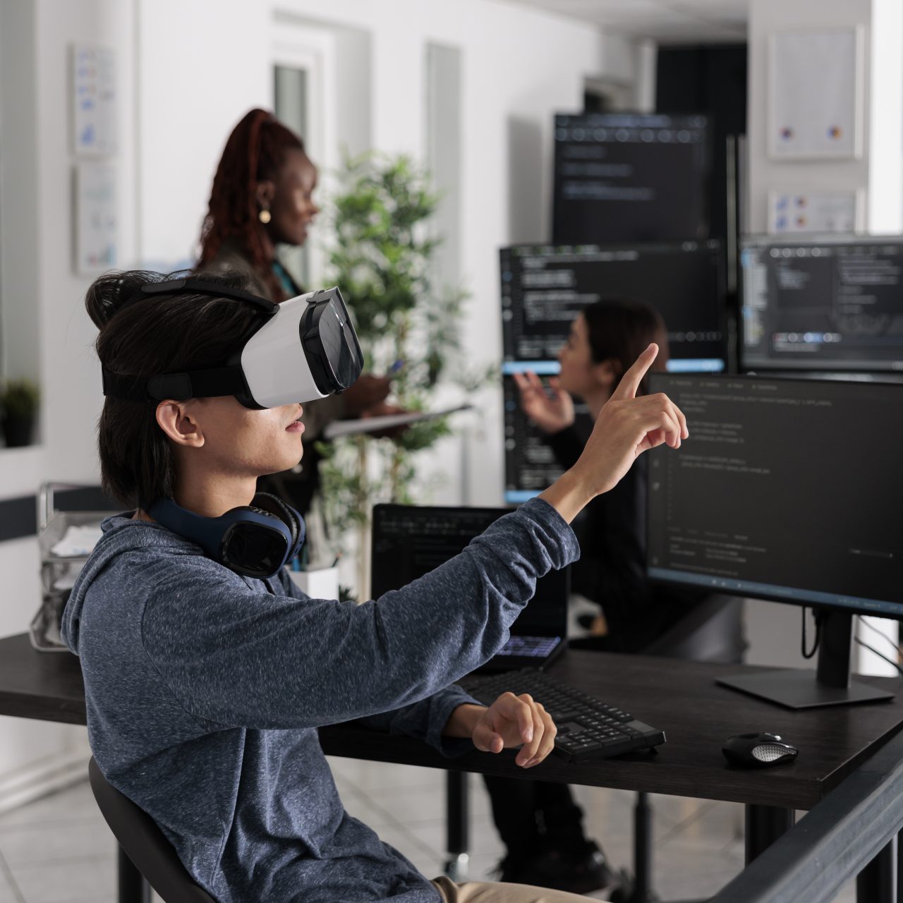 Software developer wearing virtual reality headset working to develop security program in it software company office, Big data admin with vr goggles coding html script with database.