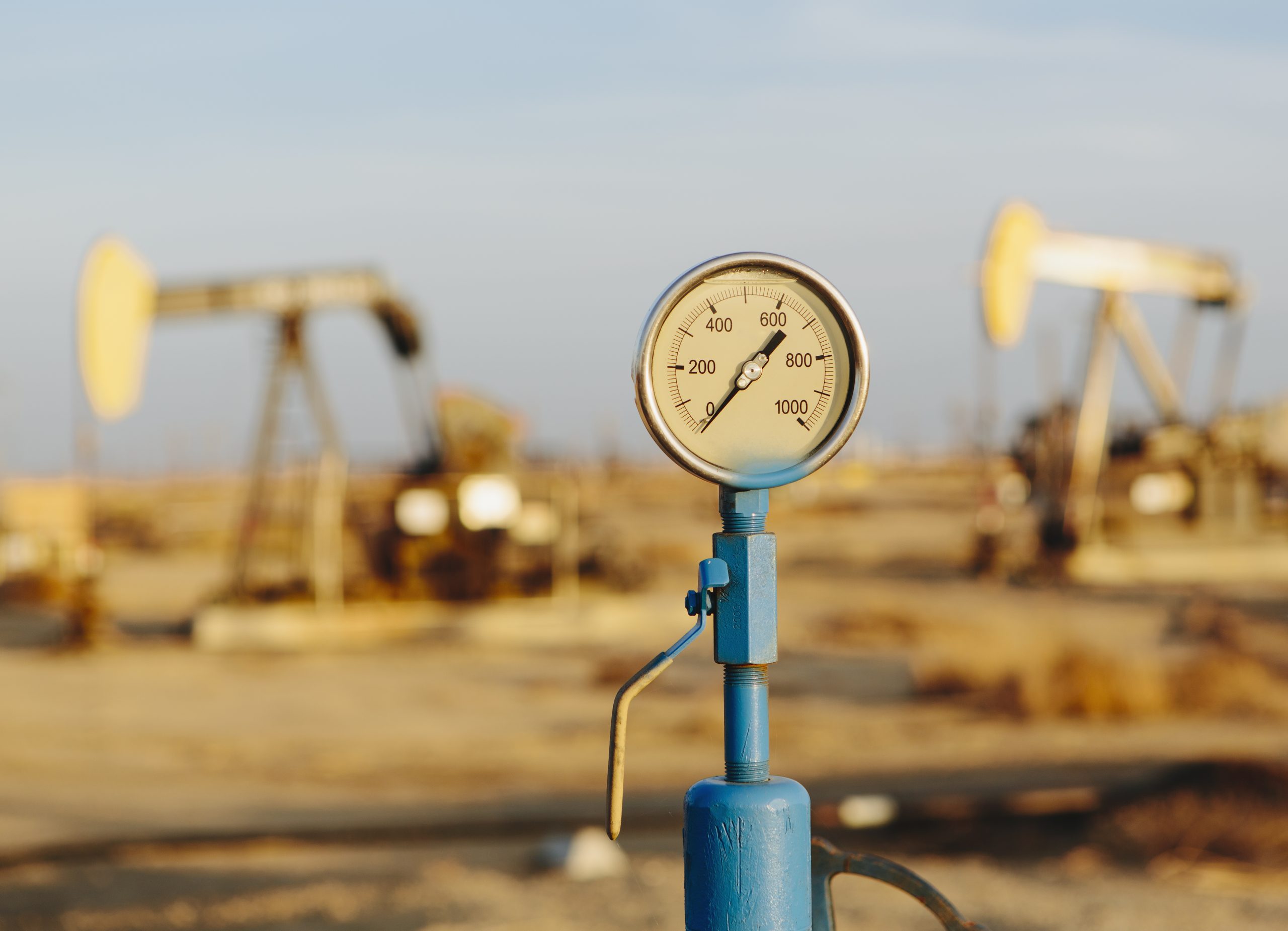 Pressure gauge with oil pumping equipment in the background