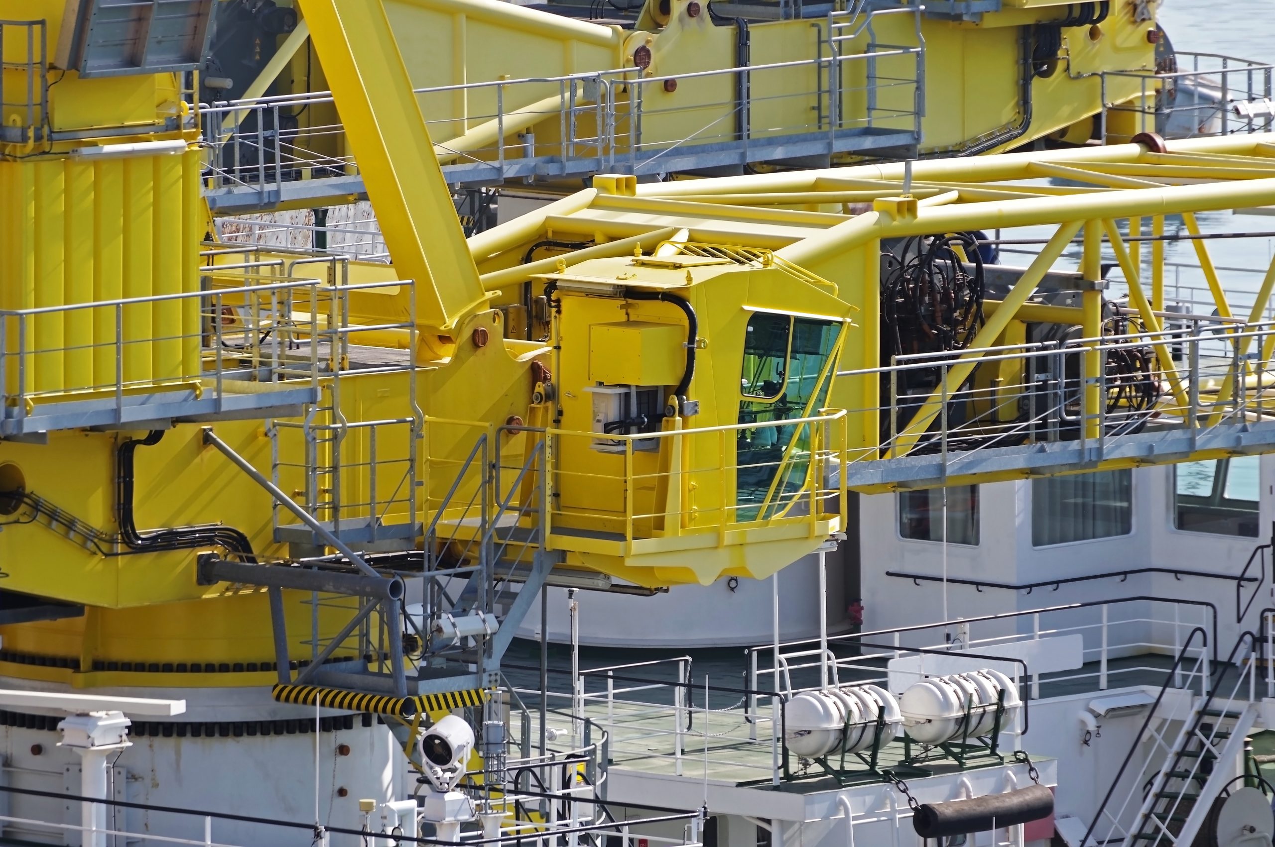 Yellow marine crane on a white vessel