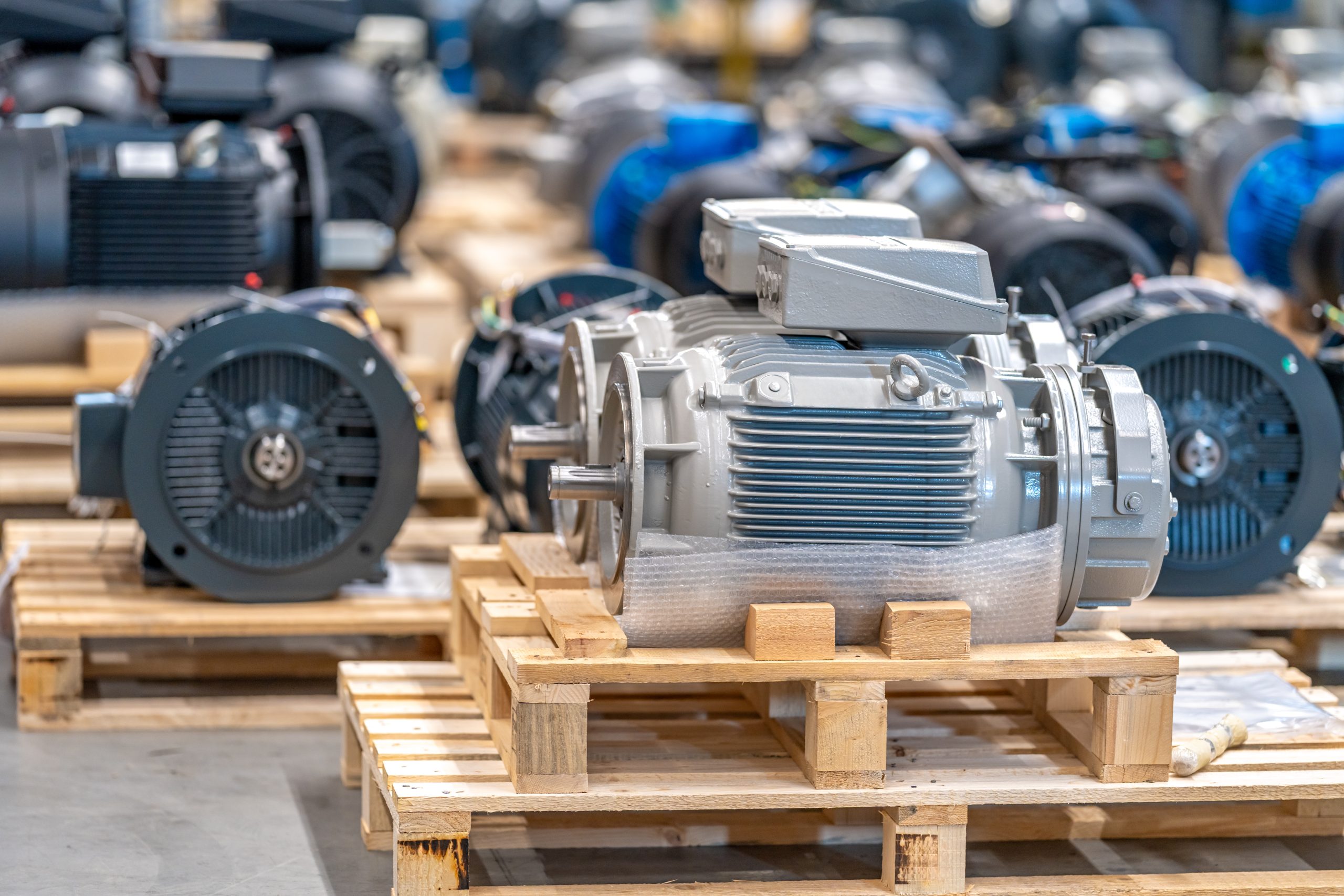 Grey electric motors on wooden pallets in a factory