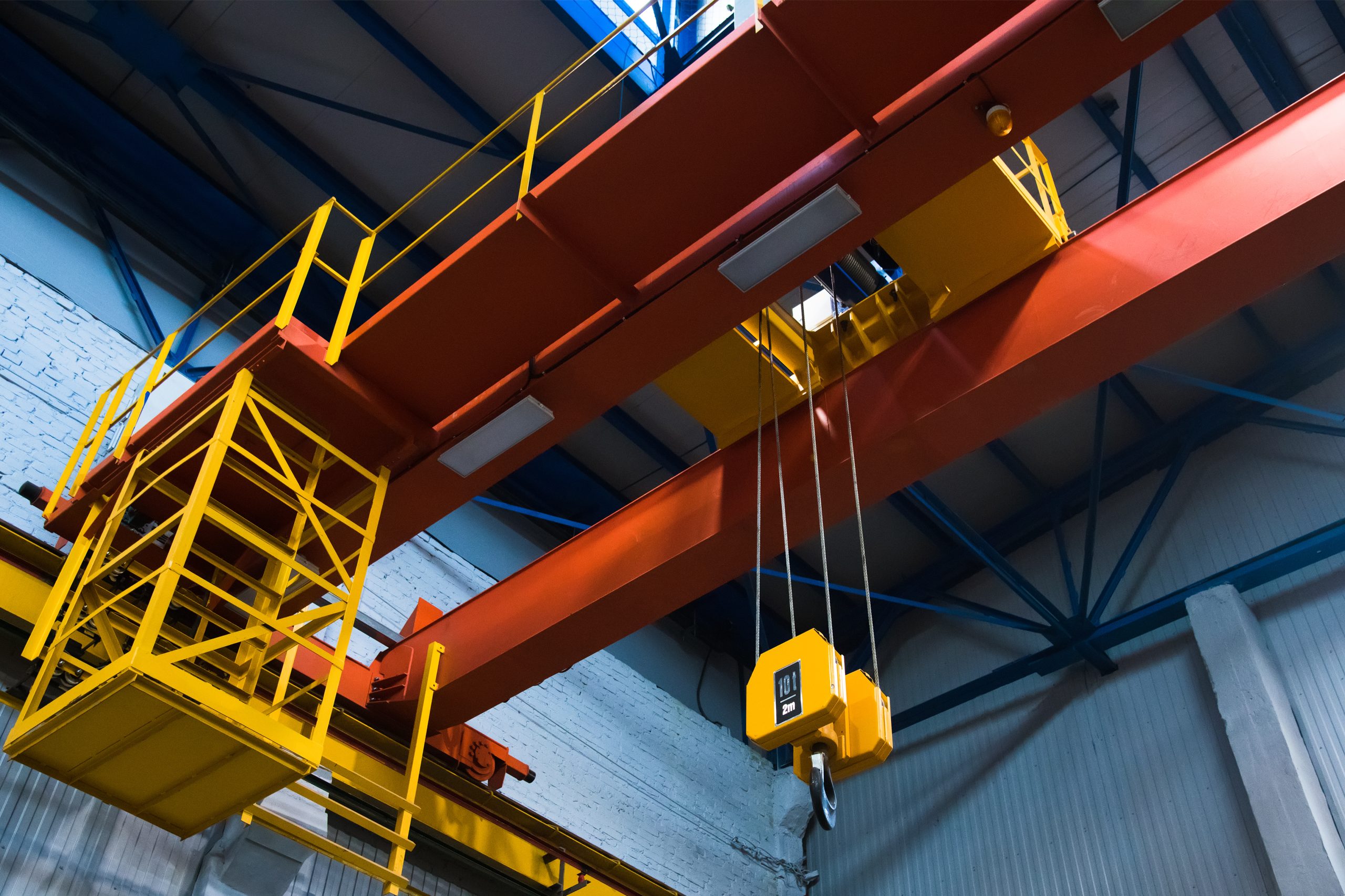 Industrial overhead crane and lifting hook inside a manufacturing facility