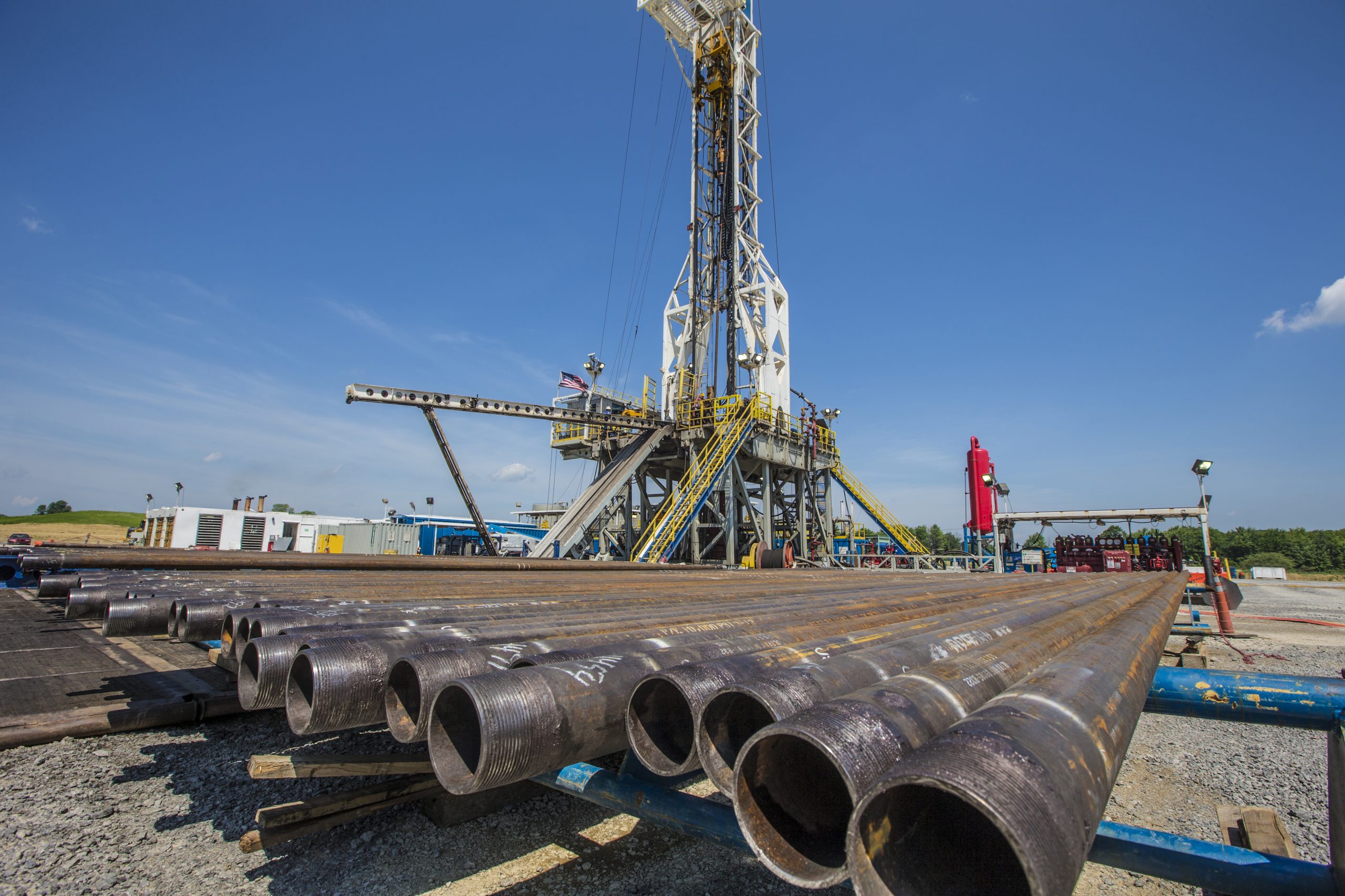 Industrial drilling rig and stacked metal pipes
