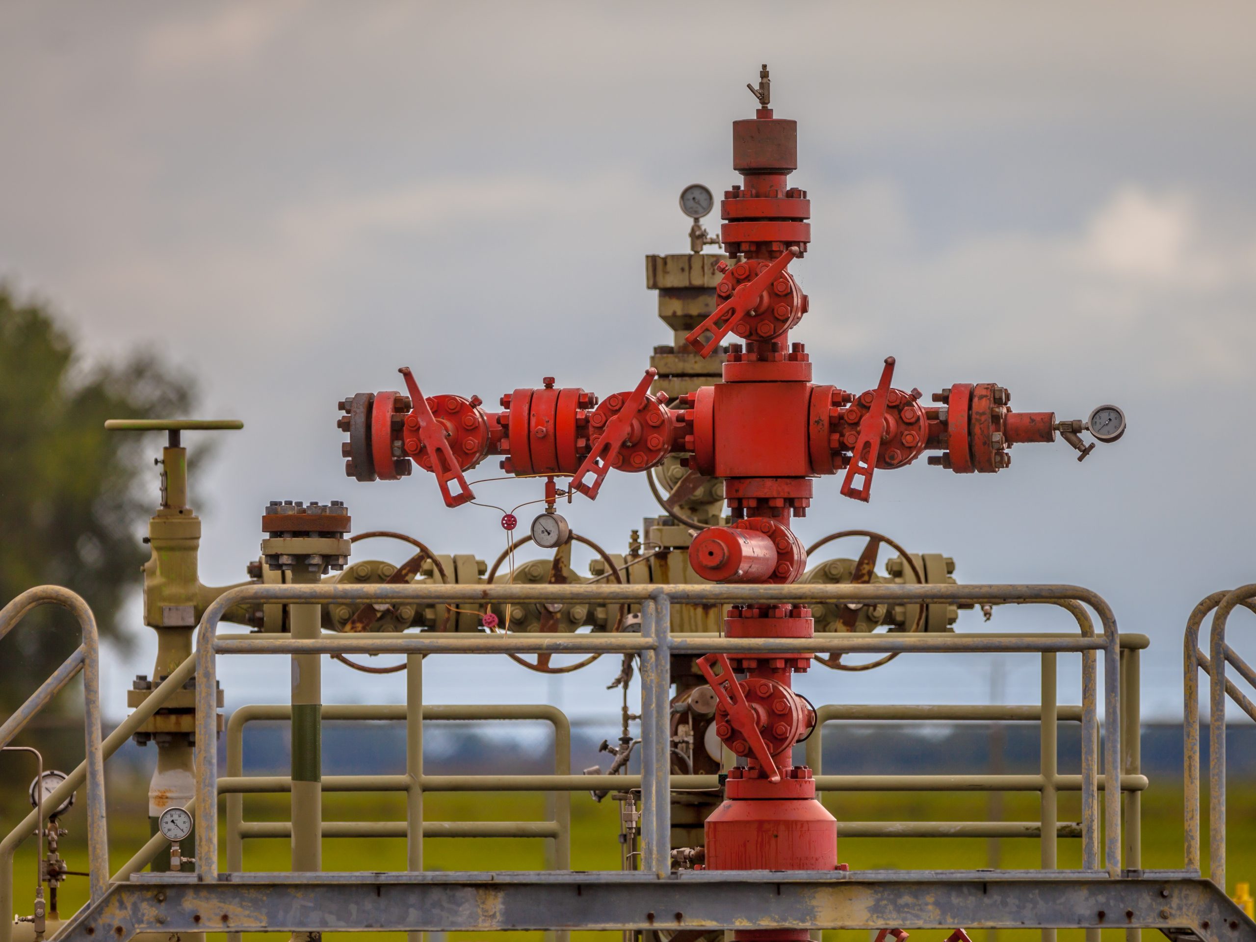 Red oil wellhead with valves and pressure gauges
