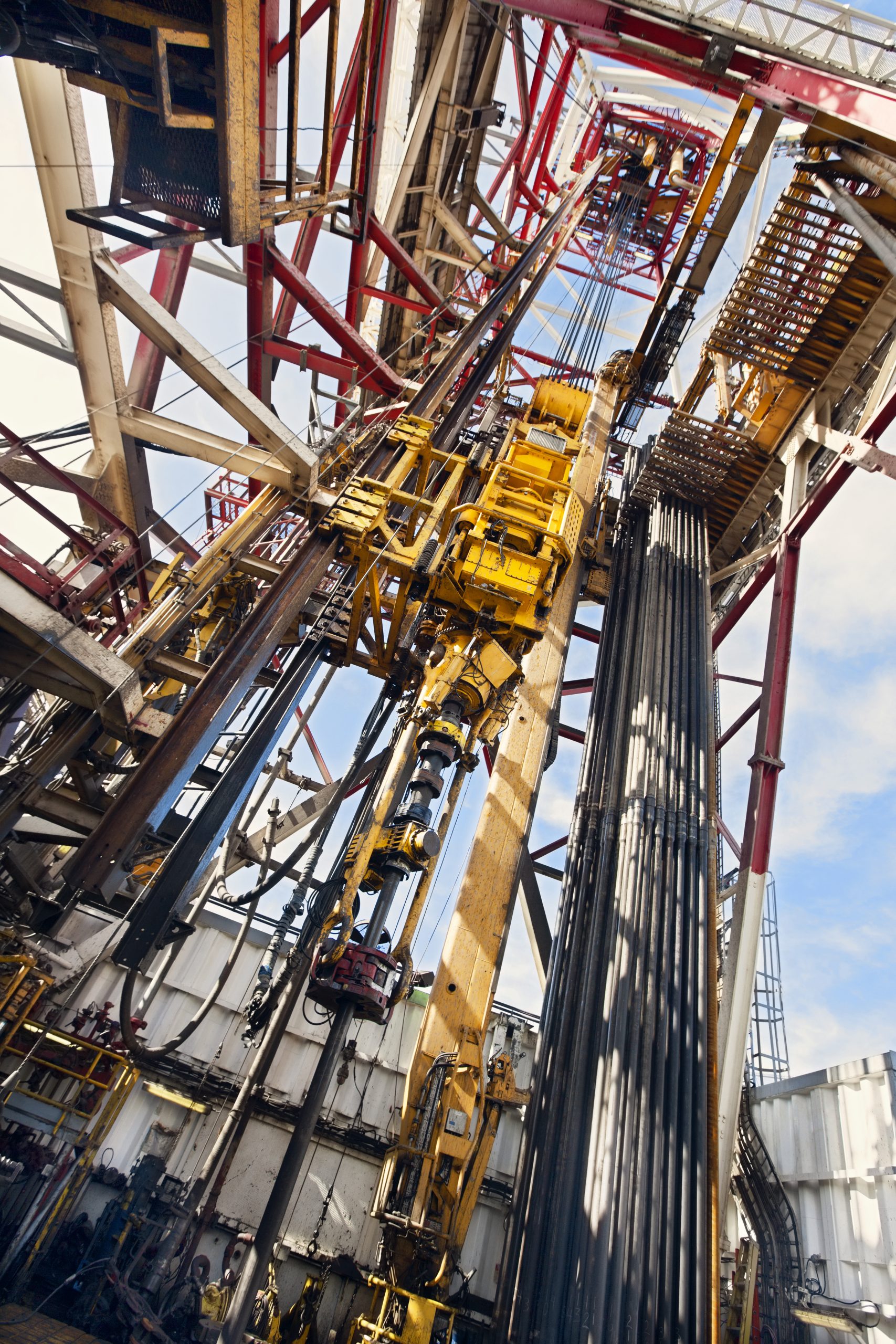 Low-angle view of an industrial oil drilling rig and machinery