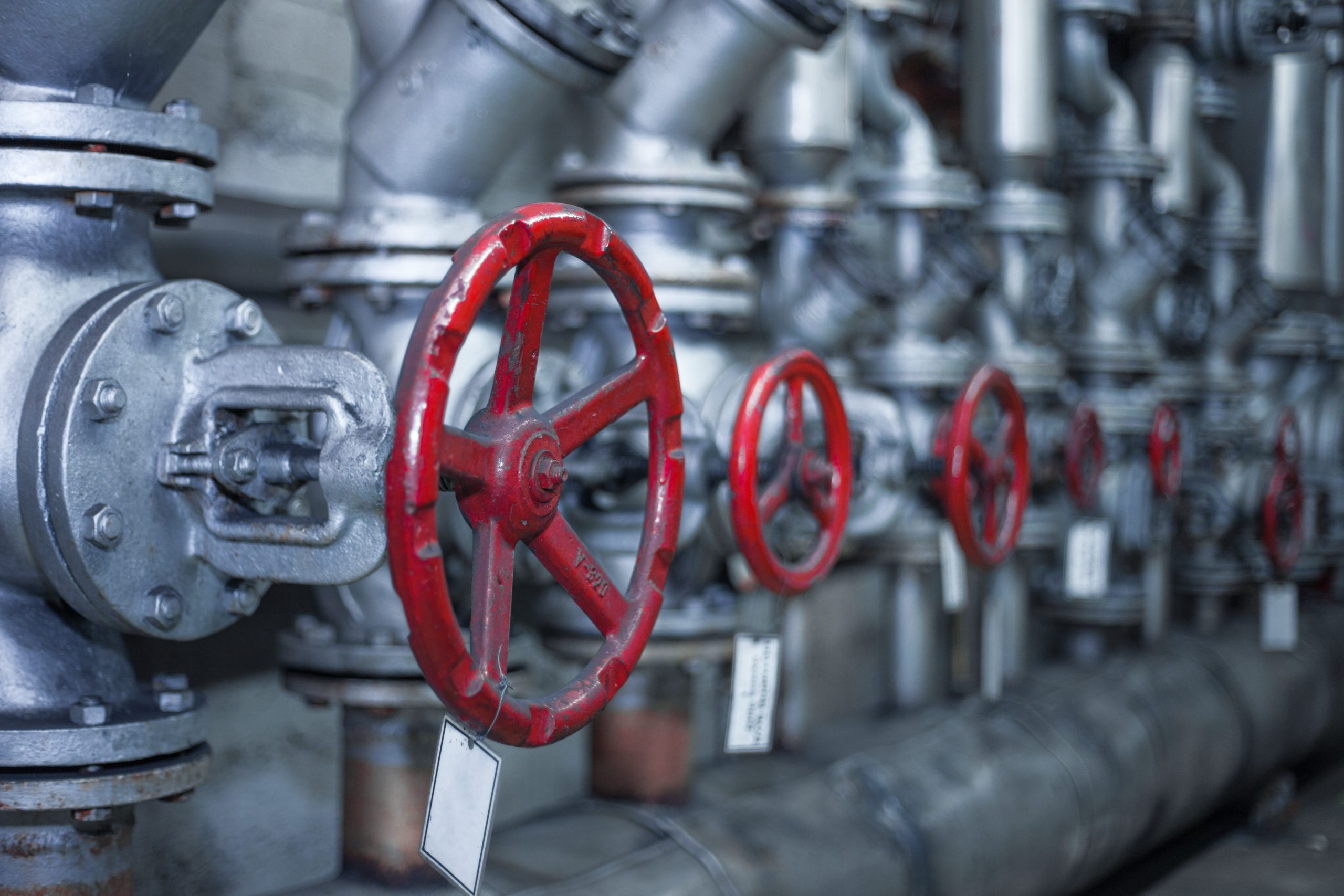 Industrial pipes and valves with red handwheels